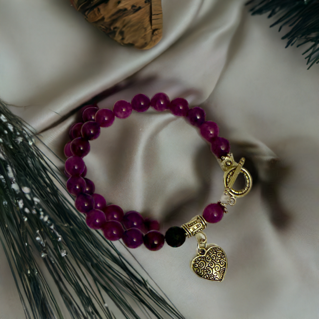 Diffuser Bracelet with purple amethyst beads and silver heart charm on cloth fabric background